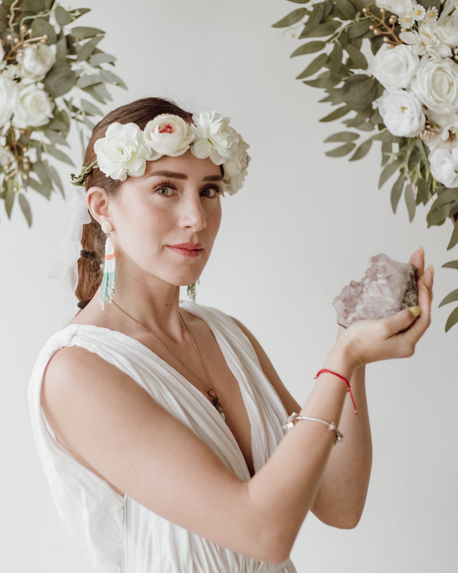 esbeidy-con-vestido-blanco-y-corona-de-flores-sujetando-una-caracola