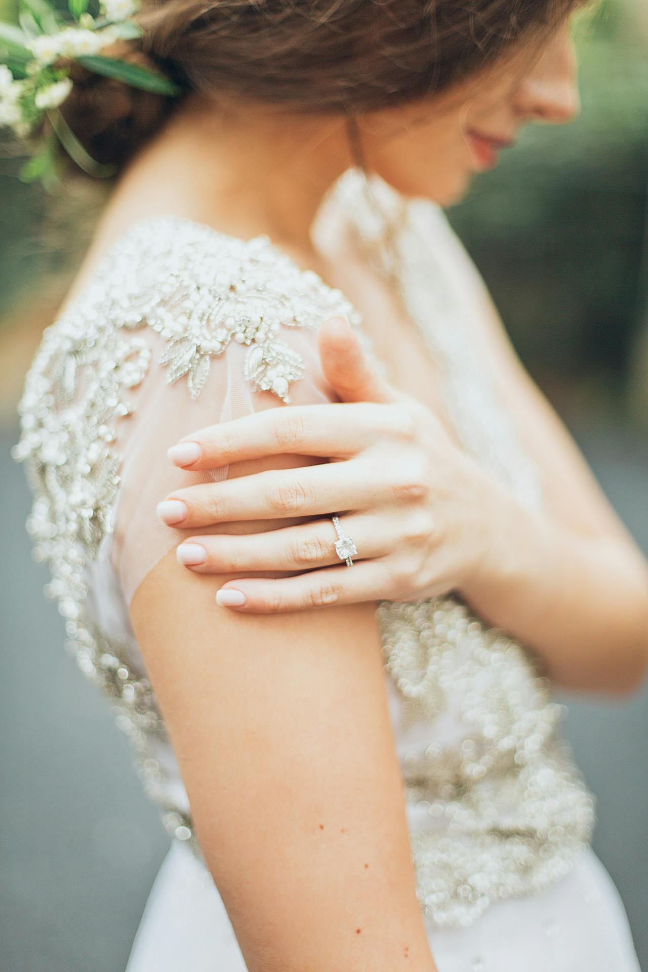 una-novia-de-perfil-tomándose-del-hombro-con-un-anillo-en-su-dedo-anular
